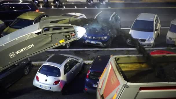 ROMA, ITÁLIA - ABRIL 9, 2021: Pesado caminhão motoniveladora remoção com pressão velho asfalto arruinado e jogando poeira de asfalto dentro do caminhão de passagem para reciclagem adicional, vapor de pó de asfalto em contraste — Vídeo de Stock