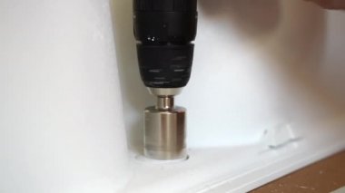 Endüstriyel elmas çekirdeği dönüyor ve beyaz seramik fayanslarda delik açıyor, farklı endüstriyel ürünlerle inşaat alanında çalışmak için bir yıkım aracı. Elmas kaplama delme deliği