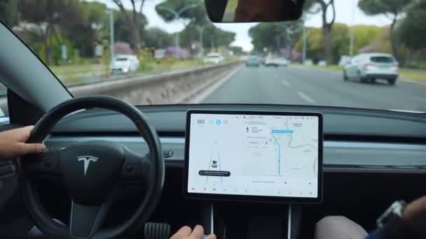 РИМ, ИТАЛИЯ - 28 апреля 2021 года: Внутренний вид инновационного автомобиля Tesla с сенсорным сенсорным экраном на переднем плане, касание водителя и прокрутка навигационного дисплея, включающего функцию автопилота — стоковое видео