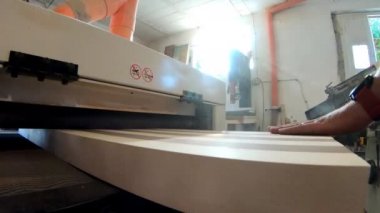 Tatmin olmuş marangoz, ahşap dizayn üretiminde son adımı atıyor, atölyede zımparalama makinesi ile yüksek kaliteli tahta cilalama yüzeyini yakından çekiyor. Zanaatkar kalası temizliyor.