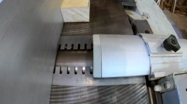 Marangoz atölyede çalışıyor, zanaatkar zımpara makinesinde ahşap çubuk kesiyor. Profesyonel tamirci mobilya üretimi için ahşap parmaklıklar hazırlıyor. Sıkı ahşap işçiliği ve marangozluk endüstrisi