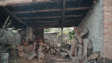 Köy evinin yıkımı kaya duvarları ve inşaat iskeleti, çökmüş çatısı olan eski harabe ev. Terk edilmiş evdeki çöpler, eski evdeki taş ve odun çöpleri. Vandalizm içeri