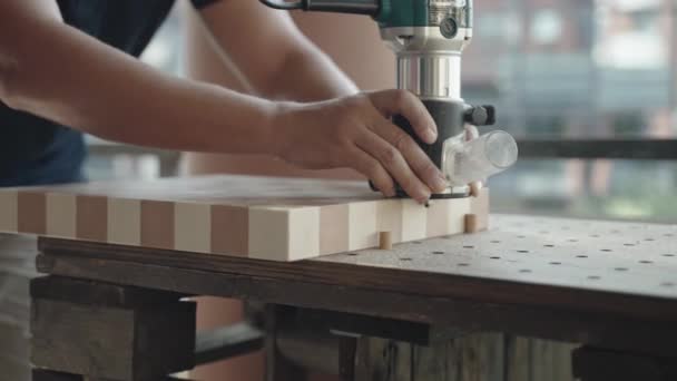 Tischler sägt und poliert Winkel von Holzbrettern mit Spezialschleifmaschine in Werkstatt, Arbeiter ohne Schutzhandschuhe poliert Oberfläche von Holzbrettern und bereitet Holzprodukt für den Verkauf vor — Stockvideo