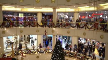 Roma, İtalya - 19 Aralık 2019: Roma 'nın büyük alışveriş merkezindeki pırıl pırıl Noel ağacı, kırmızı Noel balonlu ağaç dalları ve döşemeleri ve mağazaları süsleyen kurdeleler