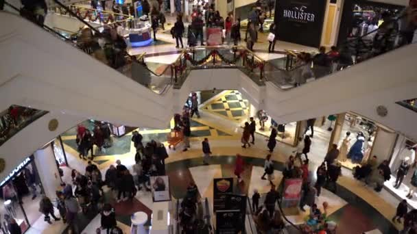 ROMA, ITALIA - 19 DICEMBRE 2019: trambusto natalizio all'interno del centro commerciale romano con decorazioni natalizie, folla di persone che salgono e scendono con la scala mobile, visitano boutique di moda, fanno — Video Stock