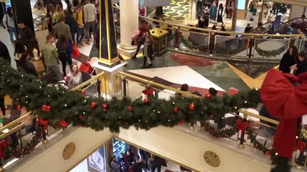 ROMA, ITÁLIA - 19 DE DEZEMBRO DE 2019: Decorações de Natal vermelhas no shopping center da cidade de Roma, pisos de mármore com iluminações de guirlandas festivas e galhos de árvores de Natal pendurados. Multidão de pessoas fazendo — Vídeo de Stock