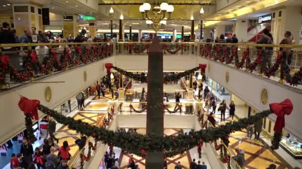 ローマ,イタリア- 2019年12月19日:ローマの有名なショッピングモールでのクリスマスの雰囲気、木の枝、ガーランド、赤いボールとリボンで飾られたショッピングセンターのインテリア。大勢の人が — ストック動画