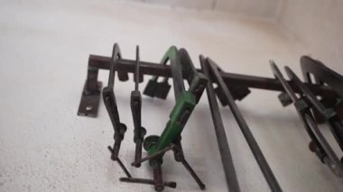 Marangozluk endüstrisinde kullanılan farklı metal kıskaçlar, çelik tahta kıskaçlar, ahşap parmaklıkları ve ağır basınçlı kalasları sıkılaştırıyor. Atölyede, marangozluk endüstrisinde duvarda asılı duran ahşap işçiliği aletleri ve