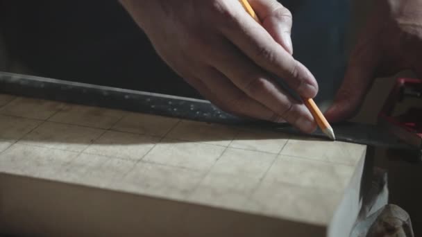 Покращений тесляр з використанням олівця і металевого лінійки для малювання на поверхні дерев'яної дошки вимірює відстань, майстер працює в майстерні з деревом, виробляючи високоякісні меблі та інші продукти. Джойнер — стокове відео