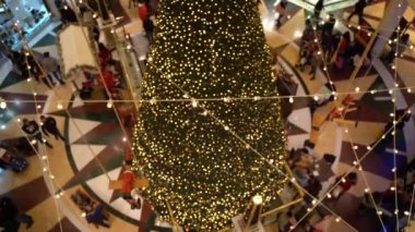 Roma, İtalya - 19 Aralık 2019: Roma alışveriş merkezindeki güzel dekore edilmiş Noel ağacının manzarası, yerde yürüyen mutlu insanlarla dolu, ve moda butiklerini ziyaret eden,