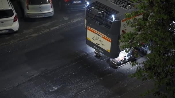 ROME, ITALIE - 9 AVRIL 2021 : Fraiseuse industrielle travaillant la nuit dans la rue de Rome, niveleuse enlever l'asphalte vieux ruiné près des parcs de stationnement se préparant à la nouvelle couche de mensonge de — Video