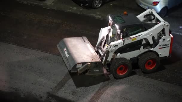 ROME, ITALY - APRIL 9, 2021: Road repairing works at night on the streets of Rome, small industrial grader removing asphalt dust from grinded part of road preparing for lying new hot asphalt — Stock Video