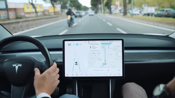 ROME, ITALY - APRIL 28, 2021: Driving autonomous Tesla car along the streets of Rome, changing function on LCD touchscreen monitor. Smart operating system of Tesla car, driving on autopilot capable — Stock Video