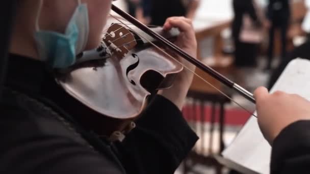 Послушная монахиня в черной рясе, играющая на скрипке во время религиозной церемонии в старой церкви в селе Тоскана, религиозный музыкант, исполняющий прославляющую музыкальную молитву на свадебной церемонии после святой — стоковое видео