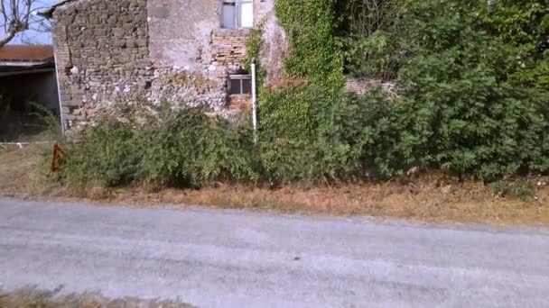 Terk edilmiş ortaçağ tuğla evinin dışındaki yarı yıkık dökük binalar ıssız bir İtalyan köyünde, iki katlı antik boş bir ev, kırık pencereli, harap olmuş tarım arazisi ve kayıp bir yol. Eski tuğla ev — Stok video