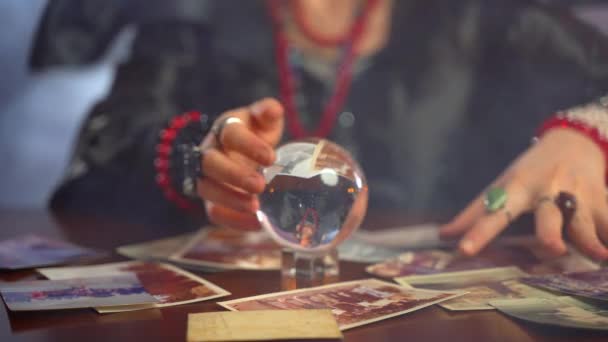 Generisk heks som utfører mystiske ritualer med krystallsfære kraft, brennende lys og bilder av savnede mennesker, sigøyner som spår om liv og fremtid for fortapte mennesker – stockvideo