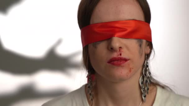 バイブレータのシルエットを背景に、目に赤いリボン、あざや血の鼻を持つ怖い女性。肉体的、感情的な暴力、拷問、女性への攻撃の後の恐怖と抑うつ — ストック動画