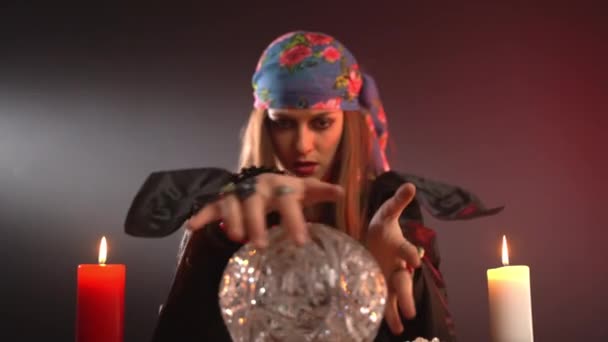 Темна відьма рухається руками над містичним кристалічним м'ячем і орфографічним зіллям, циганка робить пророцтво під час таємничих ритуалів — стокове відео