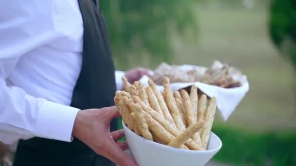 Camarero en uniforme estableciendo mesa de banquete poniendo rebanadas de pan crujiente y palos en la mesa, sirviente preparando comida para la fiesta de celebración, servicio de catering de restaurante de lujo, menú de comida exclusiva en — Vídeo de stock