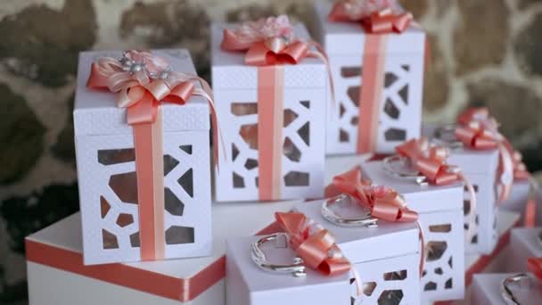 Traditionelle italienische Bomboniere-Geschenkboxen mit Geschenken im Inneren und dekoriert mit schönen Aprikosenschleifen, Konfetti-Geschenkboxen auf dem Banketttisch beim offiziellen Empfang. Party-Souvenirs für geladene Gäste — Stockvideo