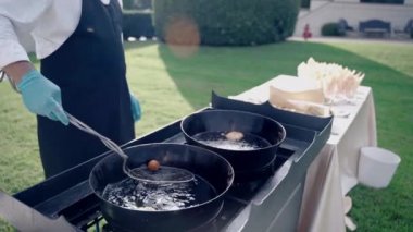 Antik Villa evinin bahçesinde özel resmi ziyafet partisi, siyah beyaz üniformalı restoran şefi ve davetli konuklar için kızarmış atıştırmalıklar ve aperatifler hazırlayan yemek eldivenleri, garson.