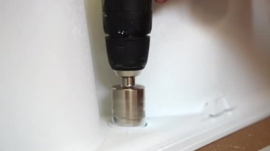 Seramik fayansta elmas kaplama sondaj deliği, dönen delme aleti ve seramik üründen beyaz toz sıçratma yakın çekim. Granit, seramik ve betonla çalışmak için kullanılan elmas kaplama