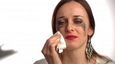 Korkmuş kadın kurban dövülmüş yüzünden gözyaşlarını siliyor korkmuş kadın acı ve ıstırapla kameraya bakıyor. Saldırıya uğrayan kadının yüzünde çürük, kadına karşı saldırı ve işkence