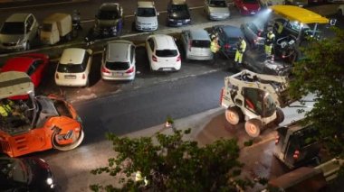 ROME, ITALY - 9 Nisan 2021: Roma caddesindeki inşaat sahasında zor yol çalışmaları, çöp tenekelerini atmak ve sıcak yolların açılması için küçük traktör kullanan takım çalışanları