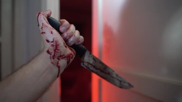 Кровавый острый нож в дрожащей руке испуганной жертвы, человек с холодным оружием, готовый напасть на опасного серийного гангстера дома. Нож как оружие самозащиты от убийцы, ужасный — стоковое видео