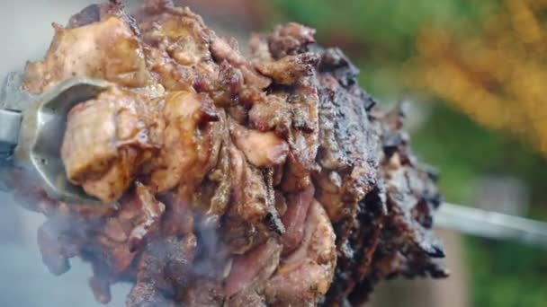İçinde ananas dilimleri olan BBC şişte kızartılmış yağlı domuz eti yanan ateşte dönen domuz eti ve kömür dumanı olan metal tükürüğü. Barbekü şişte geleneksel domuz ızgarası. — Stok video