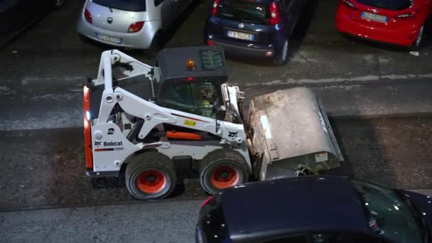 ΡΩΜΗ, ΙΤΑΛΙΑ - 9 ΑΠΡΙΛΙΟΥ 2021: Εργασίες οδοποιίας στο εργοτάξιο τη νύχτα στο δρόμο της Ρώμης, φορτηγά γκρέιντερ που αφαιρούν παλιά κατεστραμμένη άσφαλτο και καθαρίζουν αμέσως ανακατασκευασμένο μέρος αφαιρώντας το αλεσμένο — Αρχείο Βίντεο