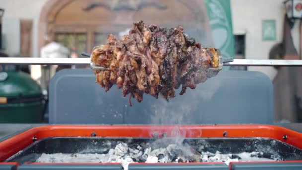 Tłusta soczysta wieprzowina obracająca się na rożnie i pieczona na szpikulcu z ananasem w środku, smaczne mięso grillujące na ogniu i rosnący dym. Przygotowanie przysmaków mięsnych na imprezę bbq, pieczenie mięsa — Wideo stockowe