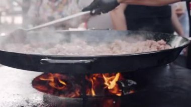 Geleneksel sokak yemekleri yarışmaları, aşçı yemek maşası kullanarak sosis pişiriyor büyük bir kazanda doğranmış soğan ve havuç kızartıyor. Baharatlı sosisler barbekü fıçısında