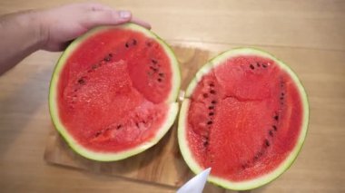 Aesthetics top view of cut ripe red watermelon on wooden board, chef cut fresh fruit with kitchen knife, juicy watermelon prepared for eating. Watermelon fruits rich of vitamins good for human body