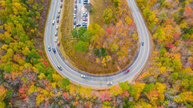 Kancamagus otobanında sonbahar ağaçlarıyla kavis ve otoparkın havadan görüntüsü
