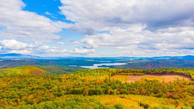 Sonbahar renklerinin değişmeye başladığı uzak gölün havadan görünüşü, New Hampshire