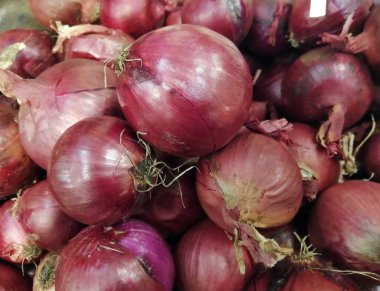 Soğanlar, henüz soyulmamış, sonbahar hasadından sonra kurumaya bırakılır. Yakın plan fotoğraf. Yukarıdan bak. C vitamini ve mikro besin değeri yüksek sağlıklı vejetaryen yiyecekler..