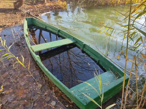 絵のように美しい湖の海岸にある古い木製の漁船 緑色の浸水したボートの写真 ベラルーシの貯水池 — ストック写真