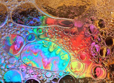 Baloncuklu gökkuşağı arka planı, su ve yağ damlalarının dokusu. Çok renkli dairelerin soyut desenleri. Yaratıcı sanat tasarımı. Kırmızı, mavi, sarı ve sarı renklerde şeffaf ıslak cam..