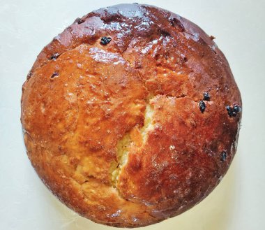 Büyük yuvarlak bir turta, altın kabuklu, fırında pişirilmiş ve masanın üzerine serilmiş. Mutfak malzemelerinin yakın plan fotoğrafı..