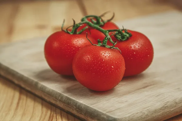 Tomates en tabla de cortar — Foto de Stock