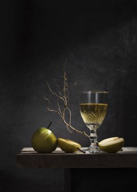 Bardakta beyaz şarap ve arka planda armut..