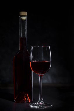 Kırmızı şarap koyu bir arka planda bir bardakta.