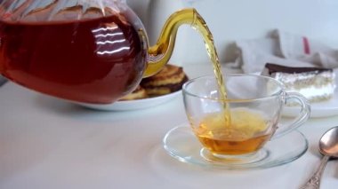 Çay çaydanlıktan bir fincana doldurulur. Ev yapımı bisküviler ve bisküvilerle kahvaltı.