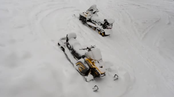 Twee sneeuwscooters zijn bedekt met sneeuw. Zware sneeuwval in januari in de Oeral — Stockvideo