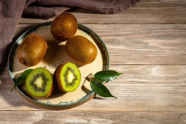 Kiwi Een Bord Een Houten Tafel Begrepen Ruimte Kiwi Snede Stockfoto