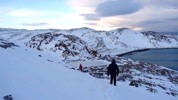 La costa del Mar de Barents a finales de febrero. Teriberka, Rusia. Los turistas descienden de la montaña — Vídeos de Stock