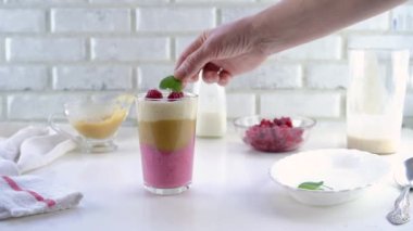 Elma soslu, ahududu ve muzlu lezzetli yoğurt tatlısı. Adım adım talimat veriyorum. Adım 8. Tatlıyı ahududu ve nane yapraklarıyla süsleyin..