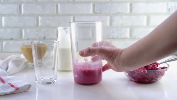 Köstliches Joghurt-Dessert mit Apfelmus, Himbeeren und Banane. Schrittweise Anleitung. Schritt 3. Den resultierenden Smoothie in ein Glas gießen — Stockvideo