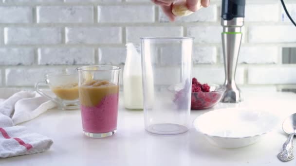 Delicious layered yogurt dessert with applesauce, raspberries and banana. Step-by-step instruction. Step 5. Put the banana pieces in a blender glass — Stock Video